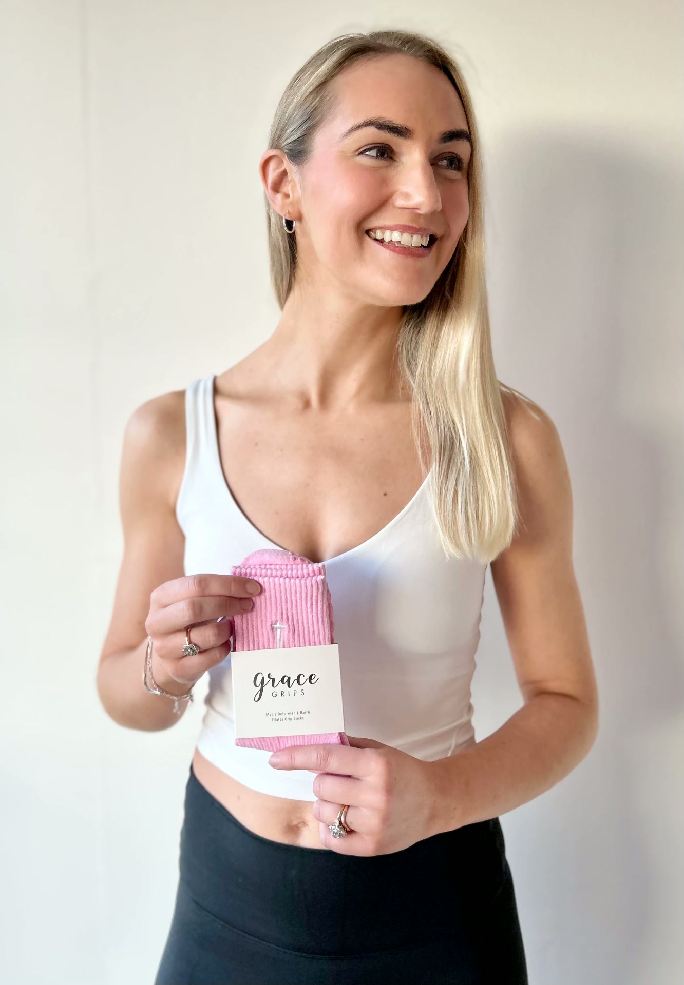 Grace holding a pair of pink Grace Grips Pilates socks